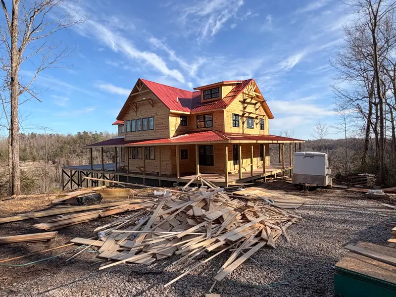 Red River Château with lumber and building materials in the foreground during construction
